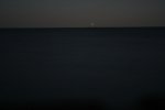 Click to enlarge A night shot of a light house off in the distance. This lighthouse is unmanned and sits upon an island all by it self.