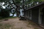 Click to enlarge Fair Haven Beach State Park, New York, United States. Cottage #12. Left side view. You can see two picnic tables, the fire pit and the pond view behind the railings.